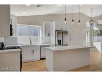 Bright, updated kitchen features stainless appliances, a kitchen island with white cabinets, and generous natural light at 4010 Herblinda Ln, North Las Vegas, NV 89032