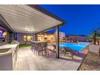 Outdoor living area with a covered kitchen, dining, lounge, and stunning pool at 461 Highview Ridge Ave, Las Vegas, NV 89138