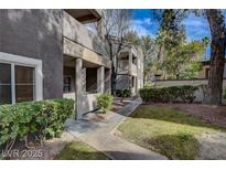 Exterior view of a multi-story condo building with well-maintained landscaping, bushes, and sidewalk at 5250 S Rainbow Blvd # 2183, Las Vegas, NV 89118