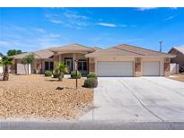Charming single-story home showcasing a well-manicured yard, three-car garage, and inviting desert landscaping at 5450 Grain Mill Rd, Pahrump, NV 89061