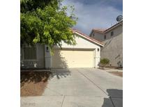 Exterior view of the home featuring a two-car garage and driveway at 5544 Cloudy Glen St, North Las Vegas, NV 89031