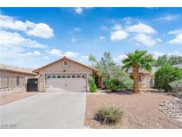 Charming single-story home featuring a well-maintained front yard with a palm tree and a two-car garage at 5884 Deer Valley Dr, Las Vegas, NV 89156