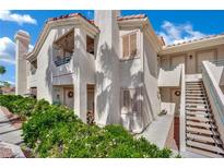 Condo exterior features well-maintained landscaping, stairways to upper units, and a neutral color scheme at 605 Devonhall St # 202, Las Vegas, NV 89145