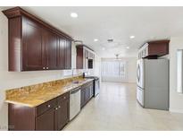 Spacious kitchen features granite countertops, stainless appliances, and dark wood cabinets at 7139 Mountain Moss Dr, Las Vegas, NV 89147