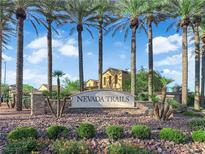 Nevada Trails community entrance with stone signage, desert landscaping, and tall palm trees against a blue sky at 7183 Majestic Bluff Pl, Las Vegas, NV 89113