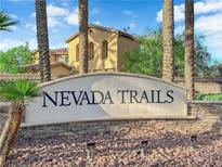 Nevada Trails community sign is set amongst desert landscaping and palm trees at 7183 Majestic Bluff Pl, Las Vegas, NV 89113