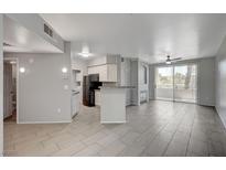Spacious living room with tile floors, modern lighting, and a sliding glass door to the outdoor patio at 7189 S Durango Dr # 208, Las Vegas, NV 89113