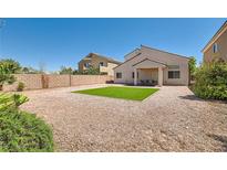 Spacious backyard with a small, rectangular grass patch, gravel, patio, and views of adjacent homes at 7856 Tolberts Mill Dr, Las Vegas, NV 89131