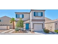 Charming two-story home featuring a stucco facade, attached garage, blue shutters, and manicured landscaping at 9979 Keephills St, Las Vegas, NV 89183