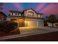 Charming two-story home with a three-car garage, desert landscaping, and a welcoming entrance, illuminated by warm lights at , Las Vegas, NV 89117