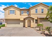 Two-story home featuring a stucco exterior, arched entryway, and a two-car garage, enhancing its curb appeal at 10638 Pueblo Springs St, Las Vegas, NV 89183