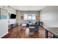 Inviting living room featuring hardwood floors, comfortable seating, and a large window with city views at 150 Las Vegas Blvd # 1118, Las Vegas, NV 89101