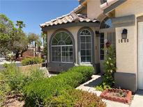 Charming home featuring a landscaped front yard, arched windows, and a welcoming front entrance at 1800 at 1800 Quail Point Ct, Las Vegas, NV 89117
