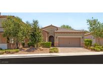 Charming single-story home with a well-manicured lawn, mature trees, and a two-car garage at 2434 Quiet Ode St, Henderson, NV 89044