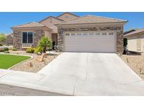 Charming single-story home featuring a stone facade, well-manicured landscaping, and a two-car garage at 2545 Nashira St, Henderson, NV 89044