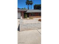 Charming single-story home featuring a gray roof, red brick, and desert landscaping at 2700 Osborne Ln, Henderson, NV 89014