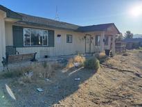 Single-story home with a cozy front porch and large front window providing plenty of natural light at 2700 W Prospector Ln, Pahrump, NV 89048