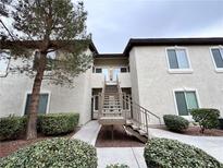 A building exterior featuring beige siding, well maintained landscaping and a stairway leading to the second floor at 3354 Indian Shadow St # 203, Las Vegas, NV 89129