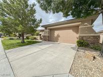 Attached two-car garage with concrete driveway and well-maintained landscaping at 3476 Ridge Meadow St, Las Vegas, NV 89135