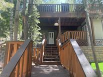 Charming multi-level mountain home featuring a wooden porch and steps leading to the front entrance at 4125 Tyrol Way, Las Vegas, NV 89124