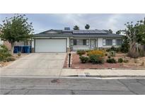 Charming single-story home with a well-maintained lawn, complemented by solar panels and a two car garage at 4564 Dennis Way, Las Vegas, NV 89121