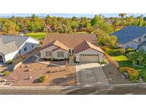 Charming single-story home with a well-manicured front yard, mature landscaping, and a two-car garage at 5009 Elm Grove Dr, Las Vegas, NV 89130