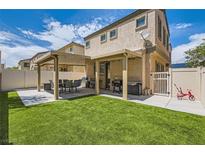 Spacious backyard featuring covered patio, outdoor seating, grill, and artificial grass for outdoor entertainment at 5409 Cruz Crest Ct, North Las Vegas, NV 89081