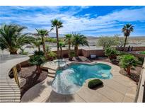Backyard view with a sparkling pool and a spa, surrounded by palm trees under a bright, sunny sky at 5949 Casa Coronado Ave, Las Vegas, NV 89131