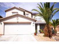 Two-story home with a two car garage, palm trees, and desert landscaping at 6141 Annville Ct, North Las Vegas, NV 89081