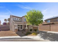 Charming two-story home with a low maintenance desert rock front yard and a long driveway with a tree in the front at 6857 Stone Tower Ct, Las Vegas, NV 89149