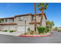 Charming townhome featuring a stucco exterior, red tile roof, two-car garage, and desert landscaping at 8012 Desire Ave, Las Vegas, NV 89128
