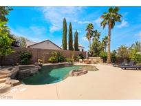 Inviting pool with rock features, mature landscaping and lounge chairs provides a backyard oasis at 11285 Fiesole St, Las Vegas, NV 89141