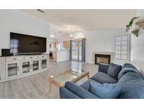 Bright living room featuring a fireplace, TV console, and sliding glass doors to the backyard at 1356 Pleasant Brook St, Las Vegas, NV 89142