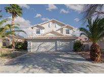 Two-story home boasts a three-car garage, tile roof, desert landscaping, and white stucco exterior under a sunny sky at 1924 Coralino Dr, Henderson, NV 89074