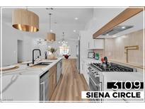 Modern kitchen featuring a quartz island, stainless steel appliances, and stylish pendant lighting at 3109 Siena Cir, Las Vegas, NV 89128