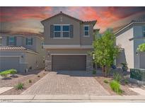 Two-story home with a two-car garage, charming stone accents, and desert landscaping at 4589 Swimming Minnow Ave, Las Vegas, NV 89141