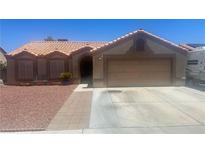 Charming single-story home featuring a desert landscape, barrel tile roof, and two-car garage at 5020 Wildroot Rd, Las Vegas, NV 89130