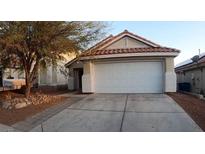 Charming single-story home featuring a two-car garage, desert landscaping and a red tile roof at 6337 Canyon Vista Ct, Las Vegas, NV 89156