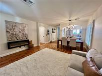 Inviting living room with modern fireplace, wood floors, and cozy furnishings at 6699 Oxendale Ave, Las Vegas, NV 89139