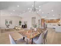 Bright, open dining area with stylish light fixture and access to a modern kitchen at 7805 Leavorite Dr, Las Vegas, NV 89128