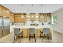 Bright kitchen boasts custom cabinets, stainless steel appliances, and an oversized island with pendant lighting at 10277 Roma Madre Ave, Las Vegas, NV 89135