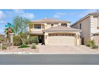 Two-story home with a large front yard, desert landscaping, and an attached two-car garage at 10948 Carberry Hill St, Las Vegas, NV 89141