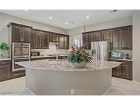 Elegant kitchen with a large island, dark cabinets, and stainless steel appliances offers abundant space at 3155 Dalmazia Ave, Henderson, NV 89044