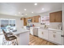 Bright kitchen boasts stainless appliances, island with seating and access to the outdoor pool at 5239 Elgin Cir, Las Vegas, NV 89122