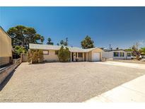 Charming single-story home featuring a gravel yard, attached garage, and mature trees at 5817 Glen Eagles Ln, Las Vegas, NV 89108