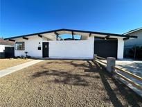 Charming single-story home with a modern exterior, desert landscaping, and unique architectural features at 6261 Rassler Ave, Las Vegas, NV 89107