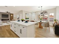 Bright, open kitchen featuring an island with white cabinets and a modern light fixture above the dining area at 6388 Canyon Dawn Ave, Las Vegas, NV 89108