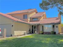 Charming two-story home with a well-maintained lawn and desert landscaping in a suburban neighborhood at 7400 Amigo St, Las Vegas, NV 89123