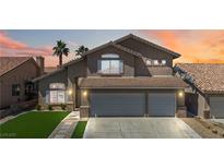 Two-story home with a three-car garage, tile roof, desert landscaping, and palm trees silhouetted by an orange sunset at 8714 Las Posas Ave, Las Vegas, NV 89147