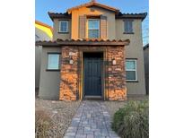 Inviting two-story home featuring a stone facade, covered entryway, and a well-maintained walkway to the front door at 1023 Brilliant Meadow Ave, North Las Vegas, NV 89086